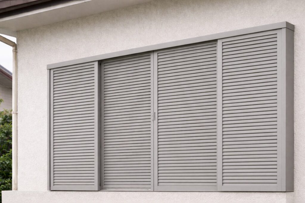 住宅の窓に取り付けられたルーバータイプの雨戸（あまど）の外観