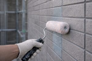 高耐久な無機塗料をローラーで外壁に均一に塗布している施工中の手元