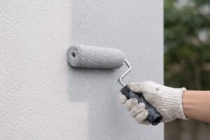 高耐久な無機塗料をローラーで外壁に均一に塗布している施工中の様子