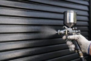 雨戸をエアスプレー塗装で仕上げている施工中の様子