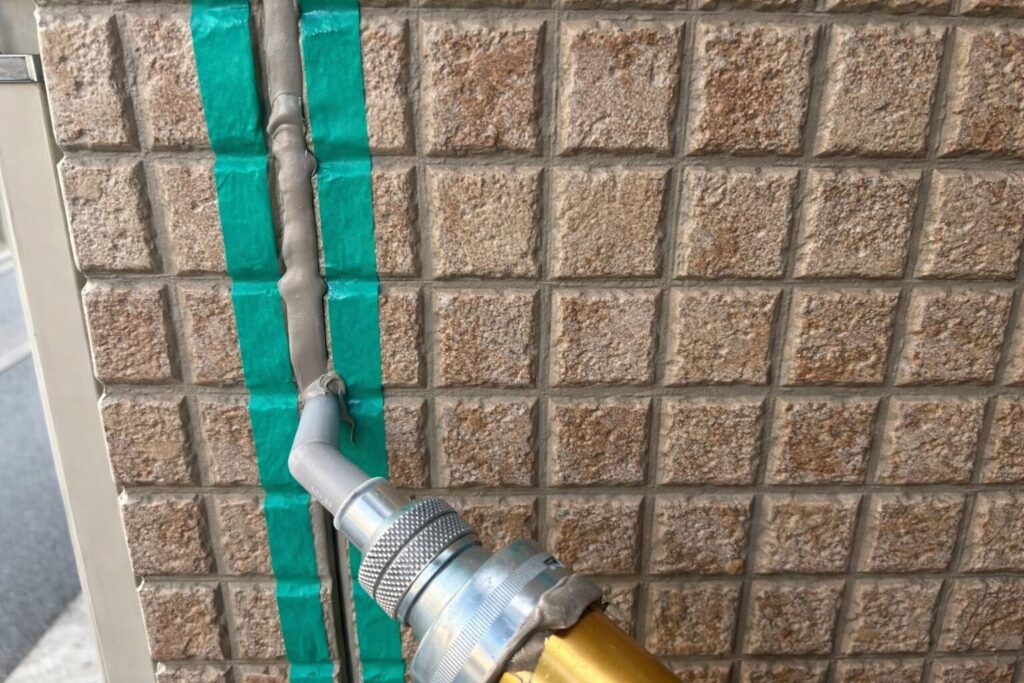 練馬区の集合住宅で外壁目地のシーリング工事に向けて養生作業を行っている様子
