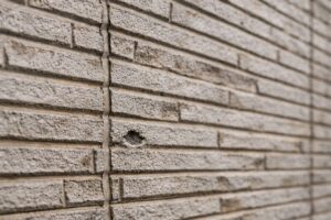 板橋区の窯業系サイディング外壁にできた小さな穴と劣化したシーリング目地の状態