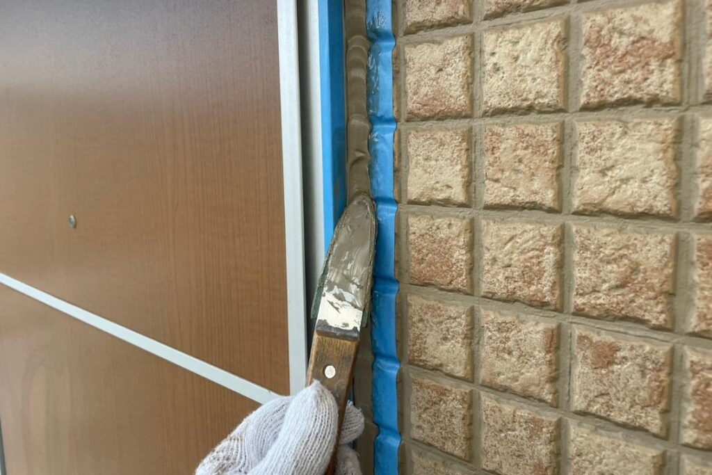 充填したシーリング材をへらで押さえ、表面を整えているドア周りの仕上げ工程
