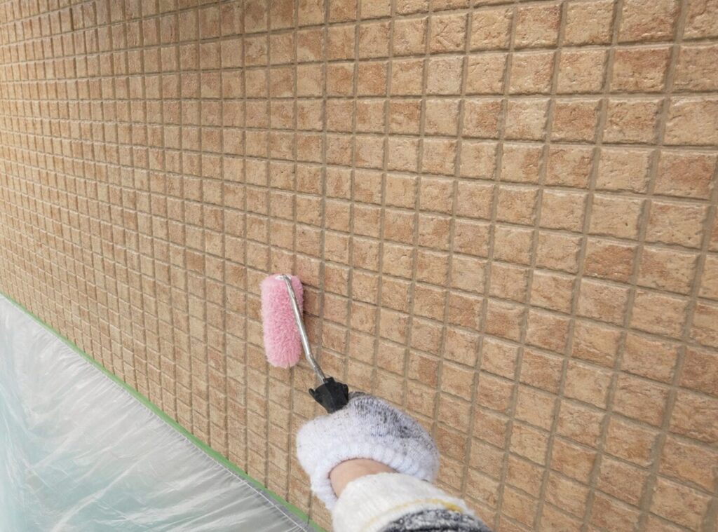 外壁表面の保護性能とツヤ感を均一に整えるため、クリヤー塗料を上塗り2回目で丁寧に塗布している施工中の様子