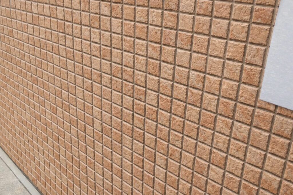 外壁クリヤー塗装の上塗り2回が完了し、タイル調デザインを活かしたまま均一な保護塗膜で仕上がった施工後の外壁状態