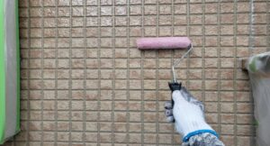 練馬区 集合住宅 外壁クリヤー塗装 クリヤー塗料をローラーで上塗りしている施工中の様子