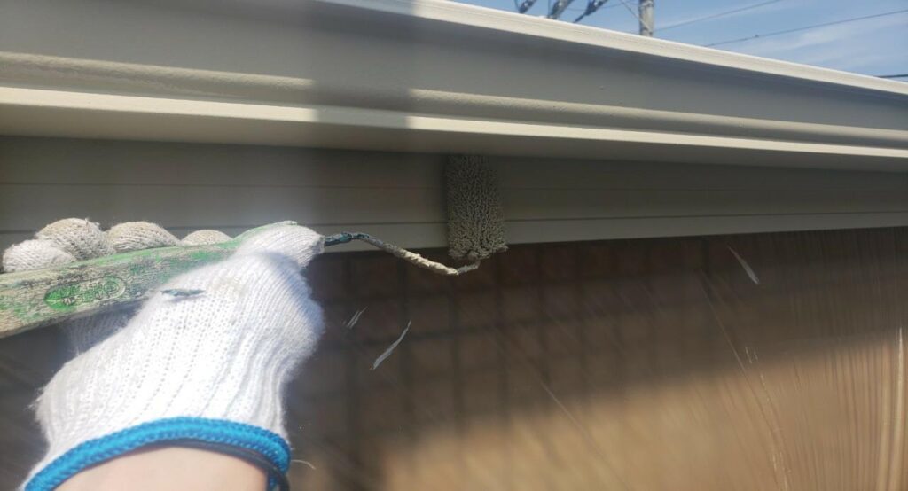 練馬区の集合住宅で、破風・鼻隠し塗装の仕上げとして上塗り塗装を行っている様子