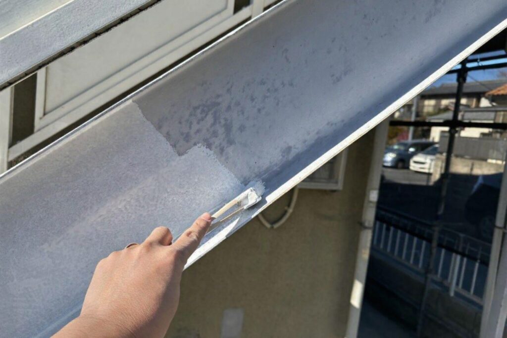 鉄骨階段ササラに錆止め塗料を塗布している様子　練馬区集合住宅