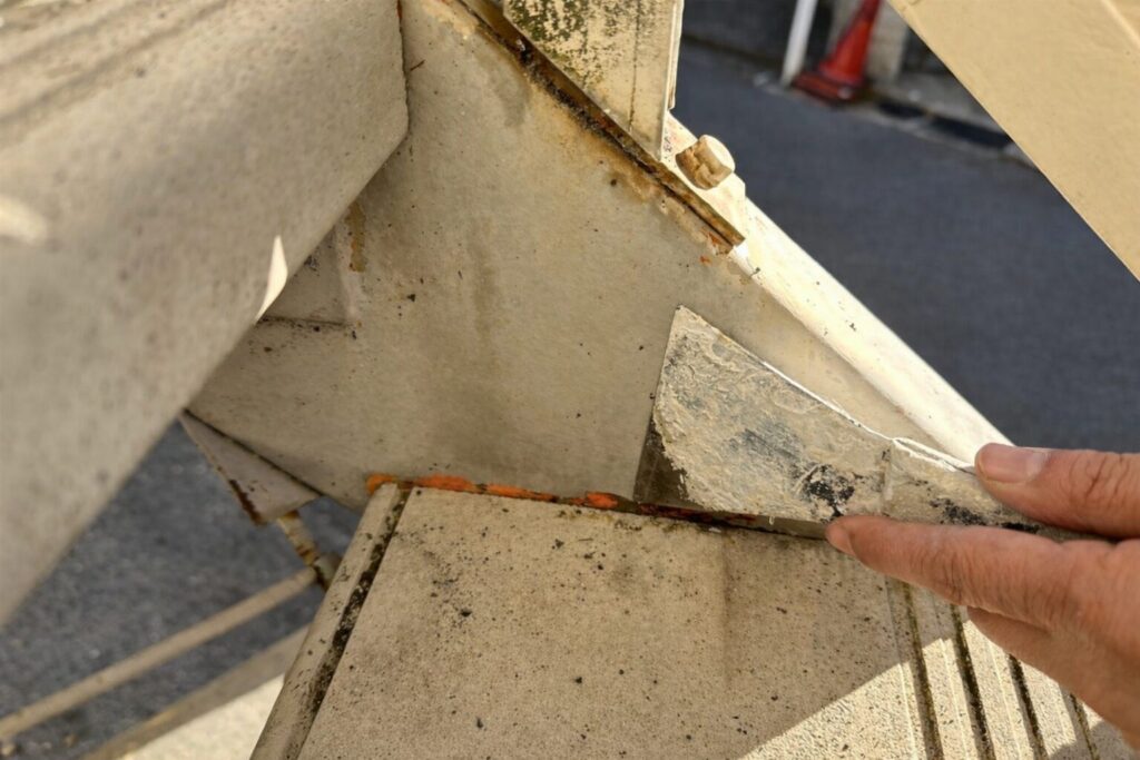 鉄骨階段ササラの取り合い部で劣化塗膜と錆を除去するケレン作業の様子　練馬区集合住宅