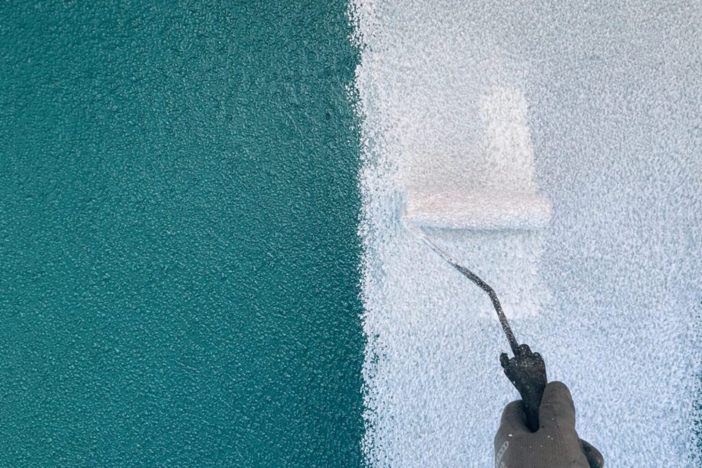 練馬区の集合住宅で外壁下地調整のためフィラーをローラーで塗装する作業