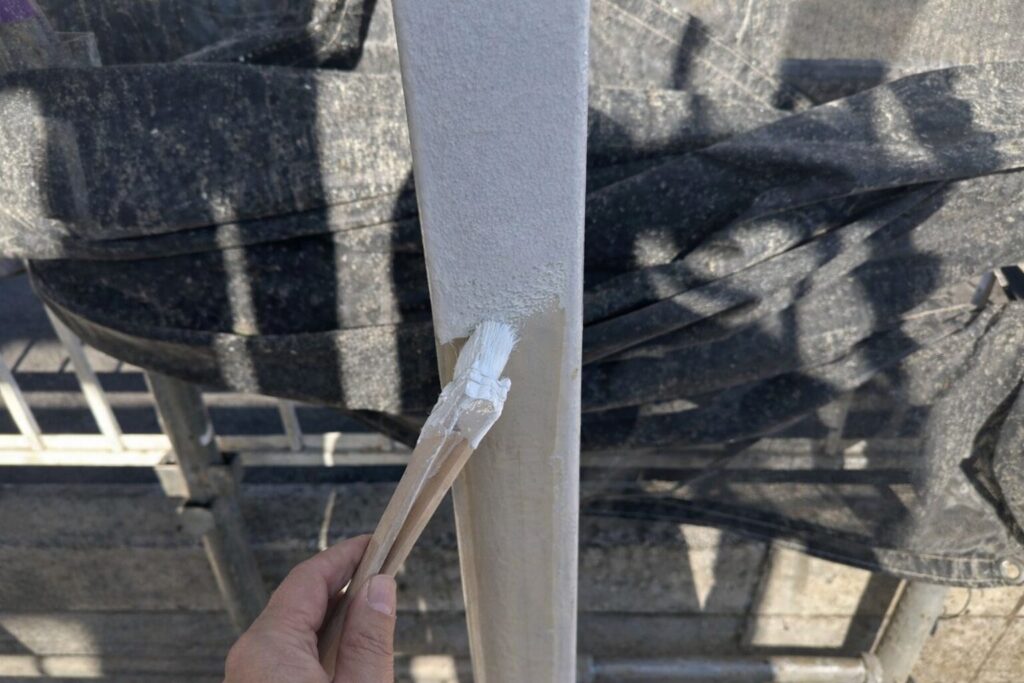 練馬区の集合住宅で鉄骨柱に錆止め塗料を刷毛で塗布する下塗り作業