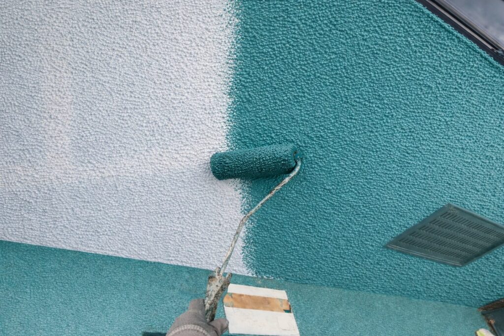 練馬区の集合住宅で軒裏天井に中塗り塗装をローラーで行っている作業